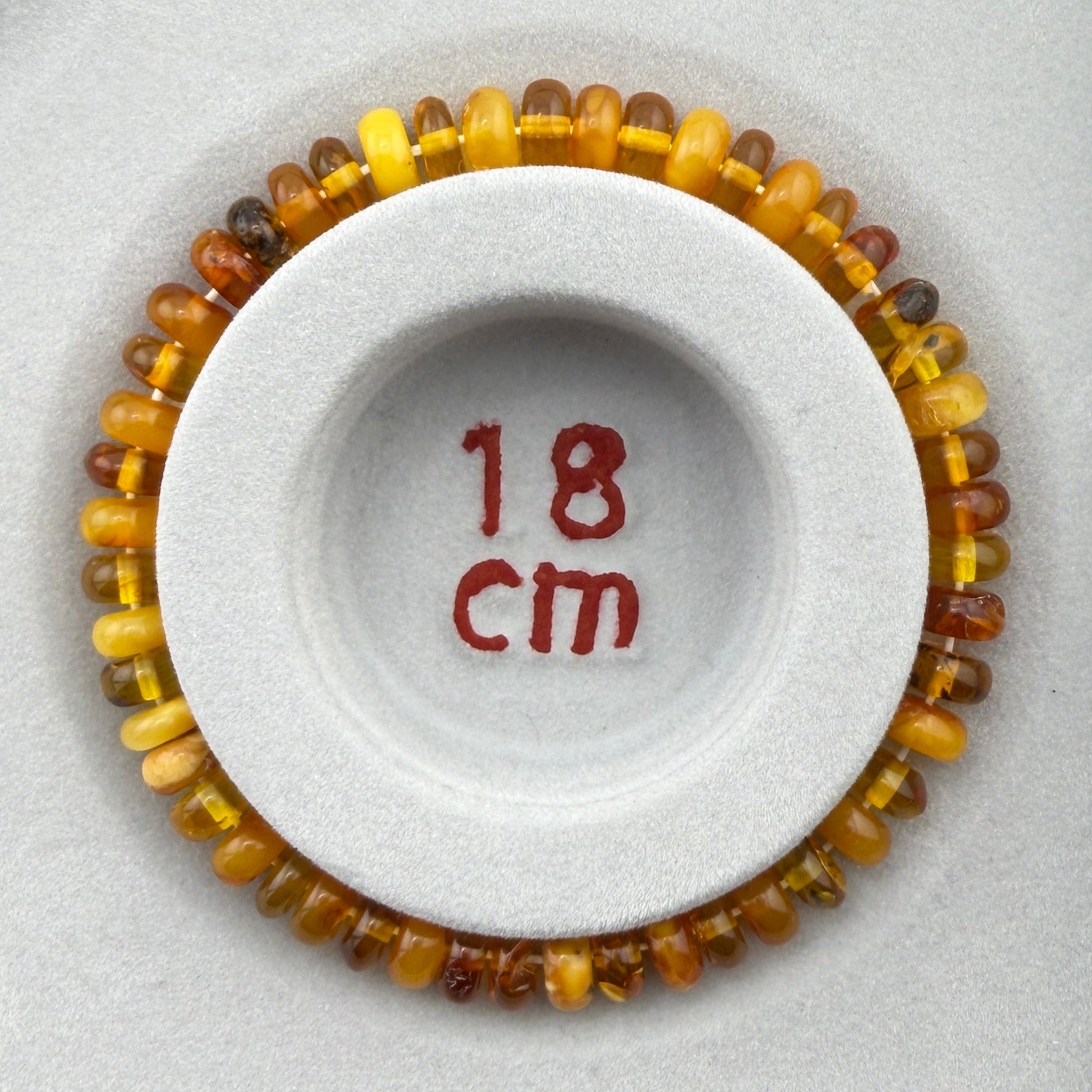 Bernstein (hell/milchig/braun) – Button-Armband 3×6 mm (elastisch, ca. 18 cm)